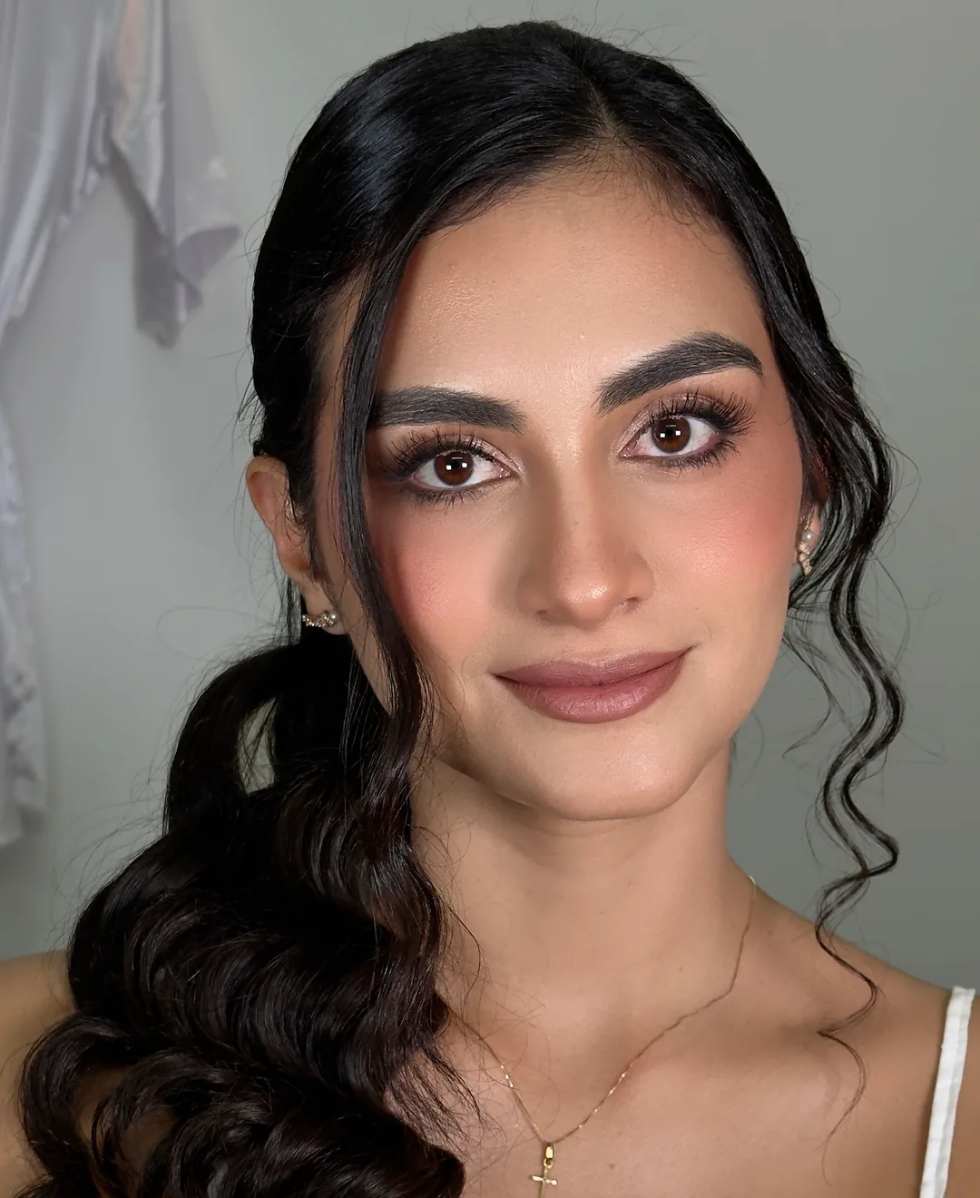 Novia con maquillaje natural, ondas y cross dorado