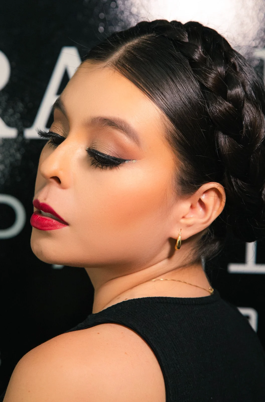 Modelo con peinado trenzado, eyeliner y labial rojo — sesión editorial Alejandra Suárez Makeup Artist