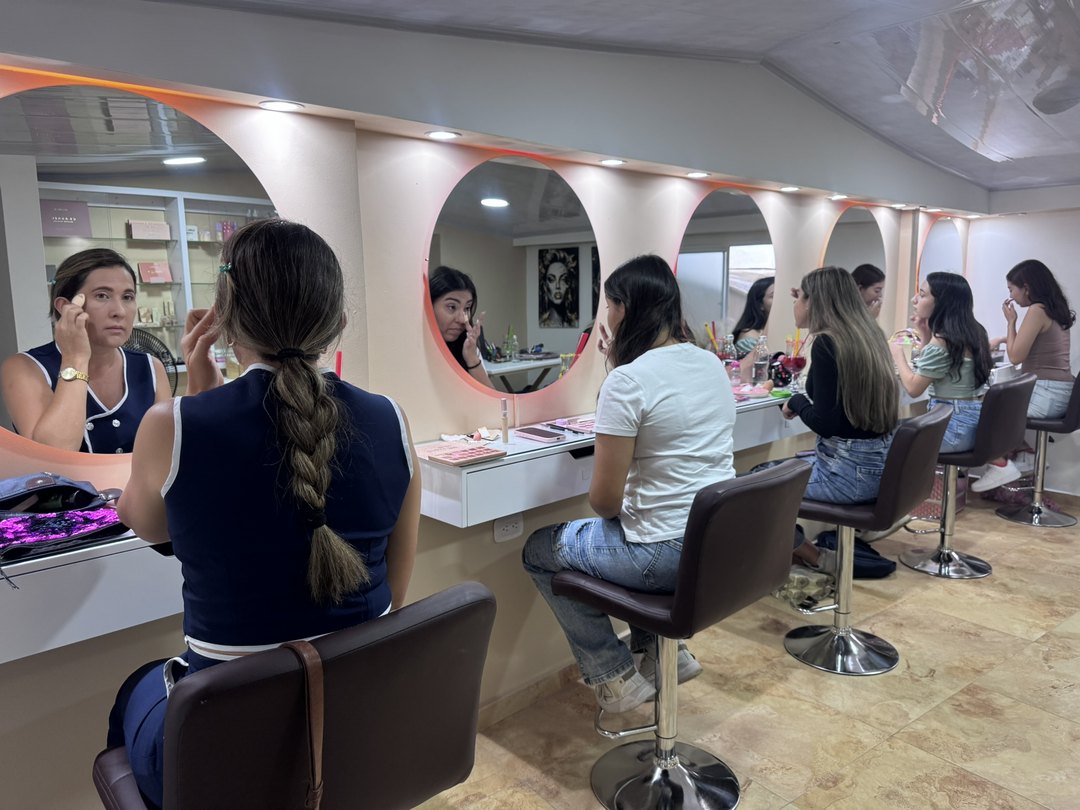 Aula de automaquillaje en estudio Alejandra Suárez con espejos iluminados y alumnas practicando