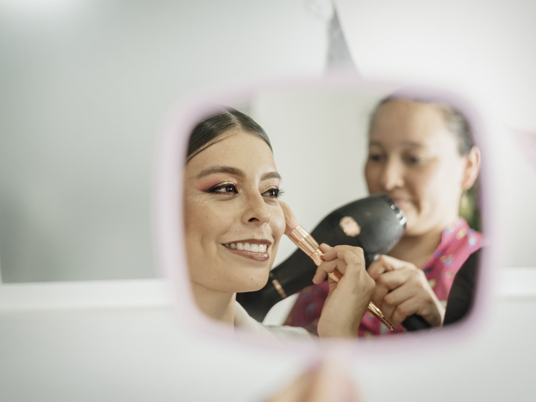 Cliente sonriendo siendo maquillada en estudio Alejandra Suárez